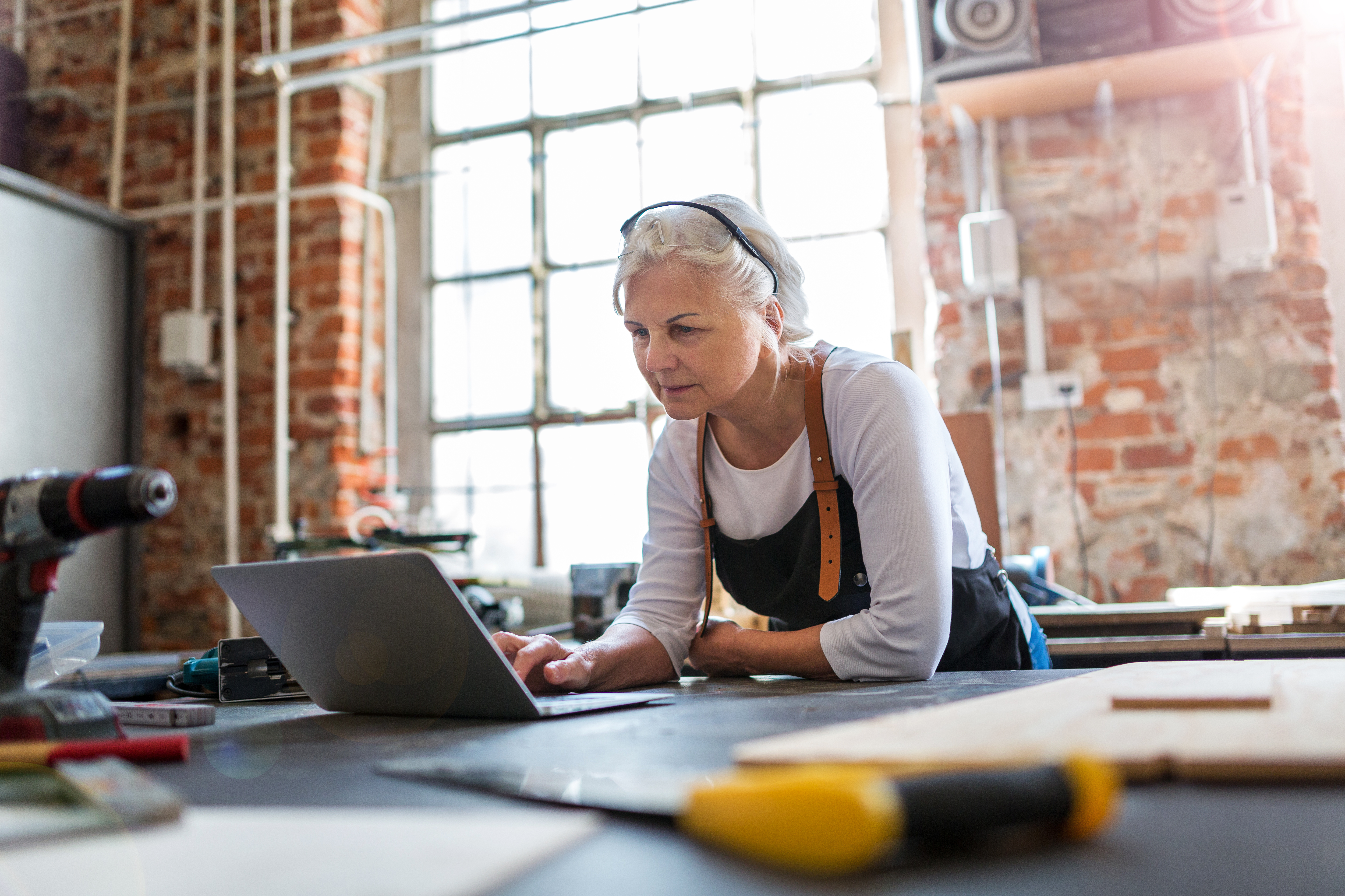 Woman leaning on desk using laptop